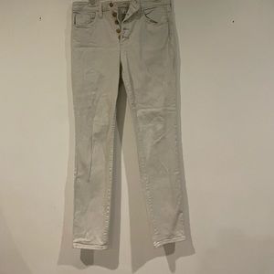 Cream colored high rise skinny jeans with button fly.